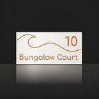 Brushed copper house number and street name sign with a brushed metal look, The Moffat, white face reading 10 Bungalow Court in copper lettering, with a wave.