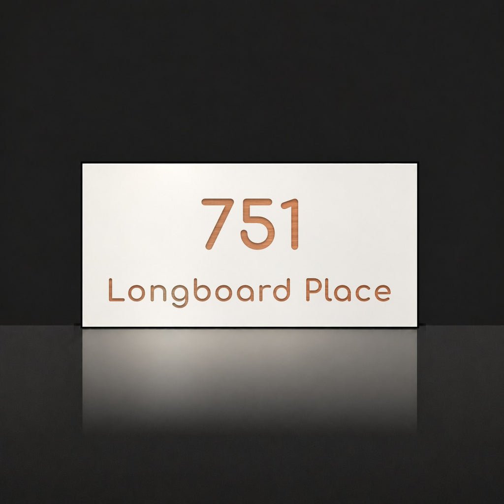 Brushed copper house number and street name sign with a brushed metal look, The Peregian, white face reading 751 Longboard Place in copper lettering.