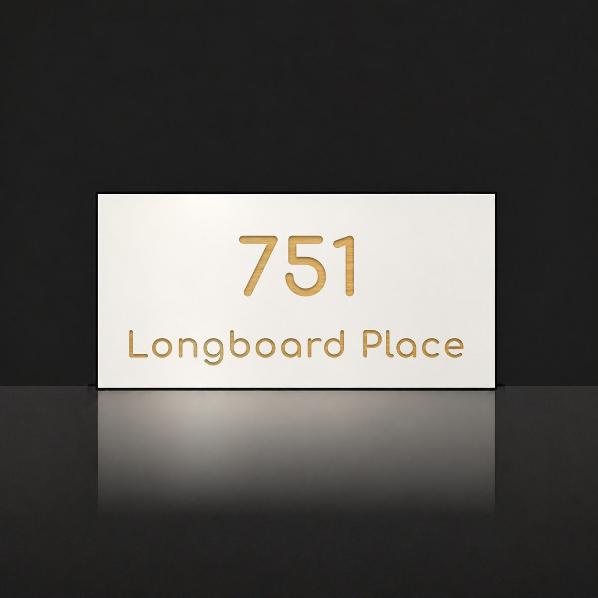 Brushed gold house number and street name sign with a brushed metal look, The Peregian, white face reading 751 Longboard Place in gold lettering.
