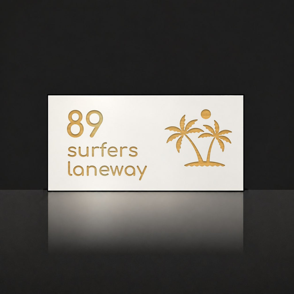 Brushed gold house number and street name sign with a brushed metal look, The Yaroomba, white face reading 89 Surfers Laneway in gold lettering, with palm trees and a sun.