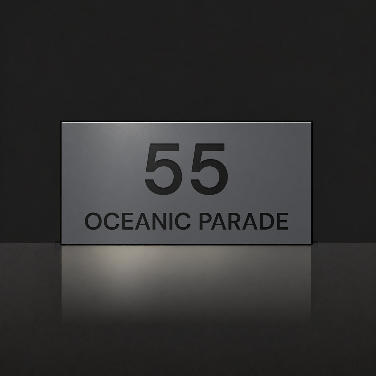 Matte charcoal house number and street name sign, The Peregian, reading 55 Oceanic Parade in black lettering.