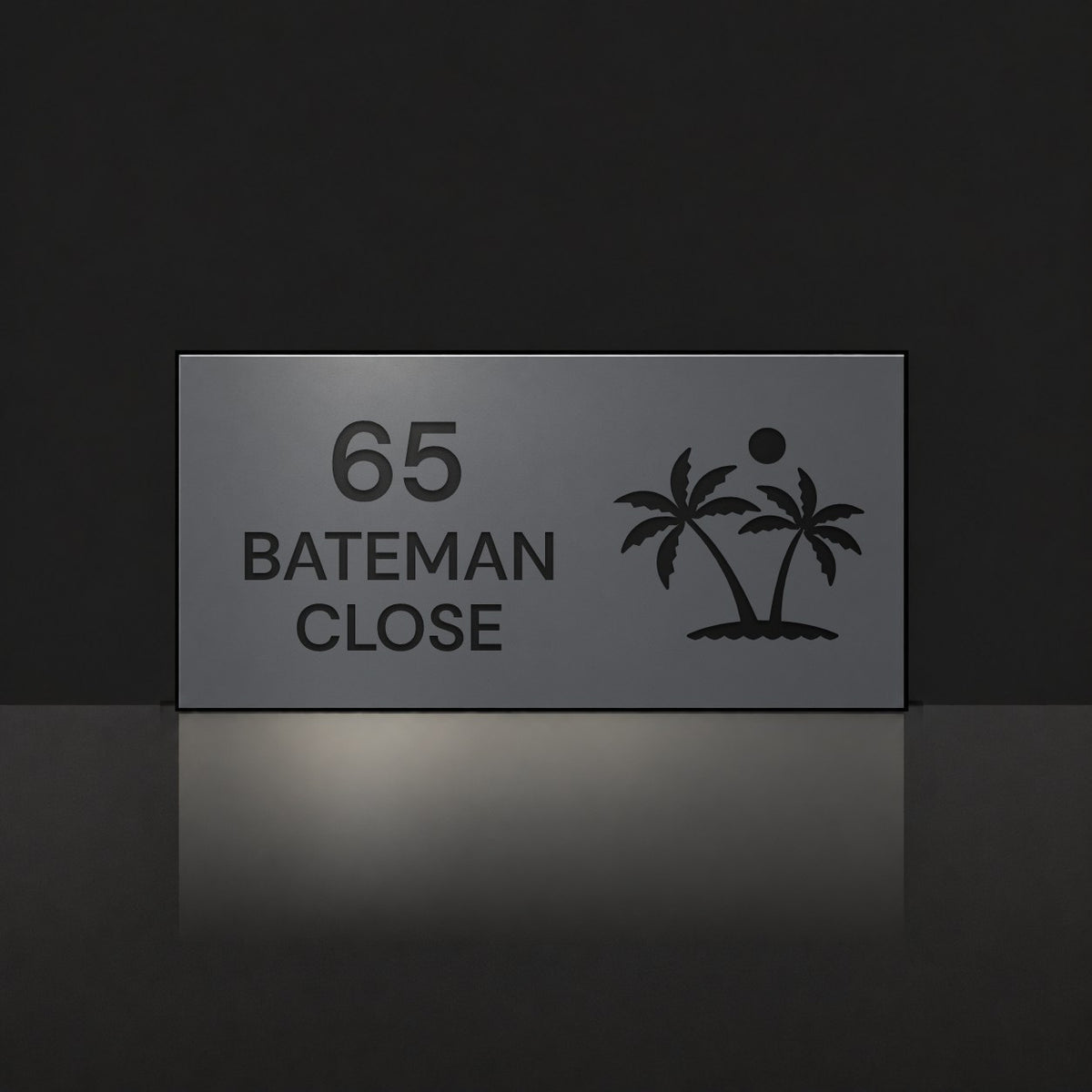 Matte charcoal house number and street name sign, The Yaroomba, reading 65 Bateman Close in black lettering, with palm trees and a sun.