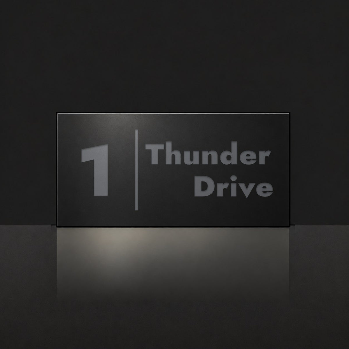 Matte black house number and street name sign, The Coolum, reading 1 Thunder Drive in charcoal lettering, with a dividing line.