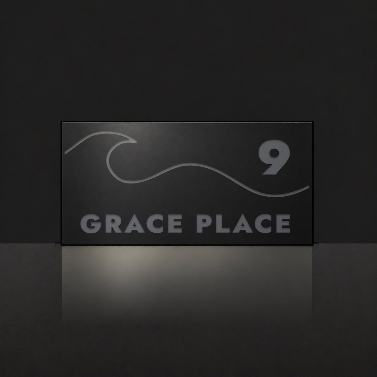 Matte black house number and street name sign, The Moffat, reading 9 Grace Place in charcoal lettering, with a wave.