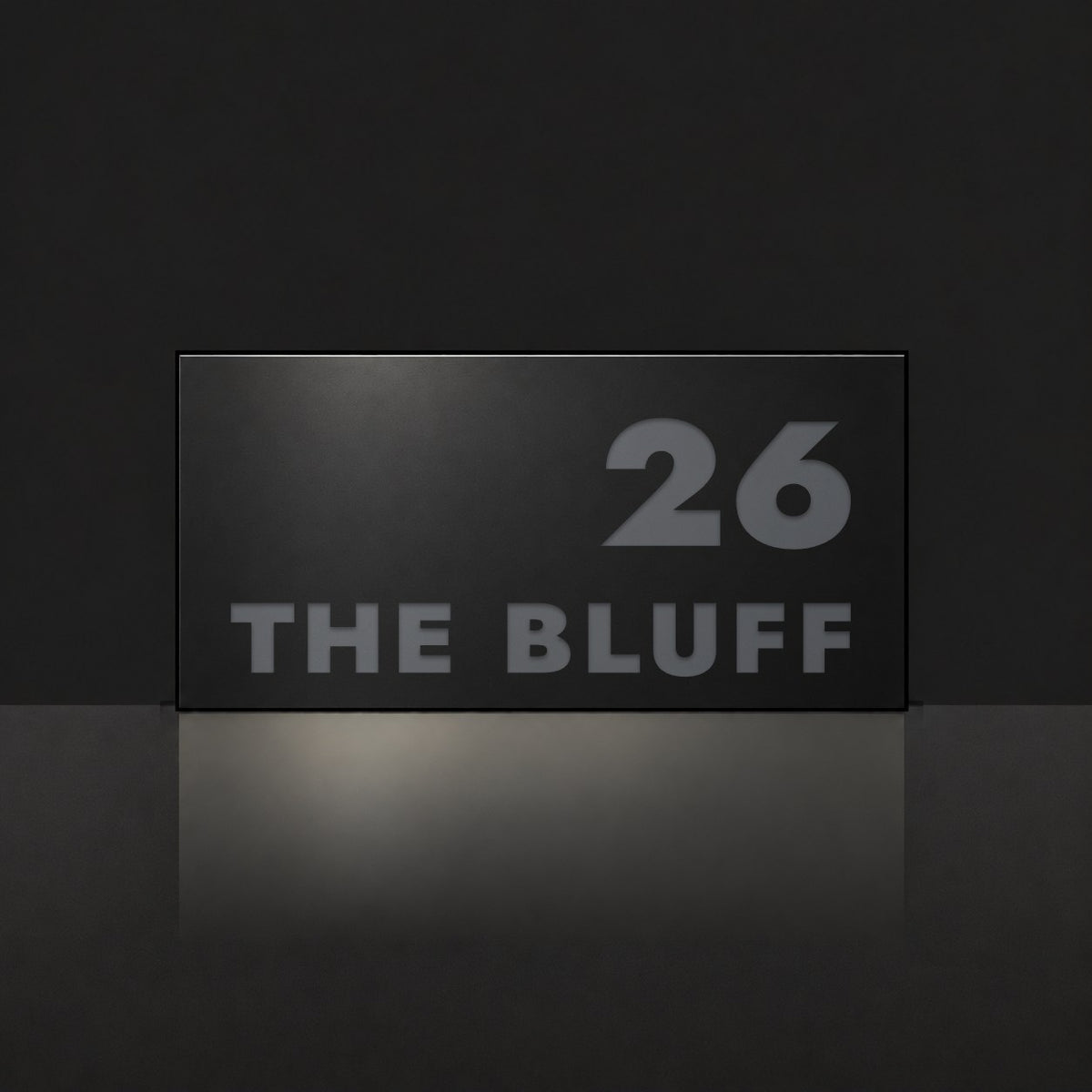 Matte black house number and street name sign, The Peregian, reading 26 The Bluff in charcoal lettering.