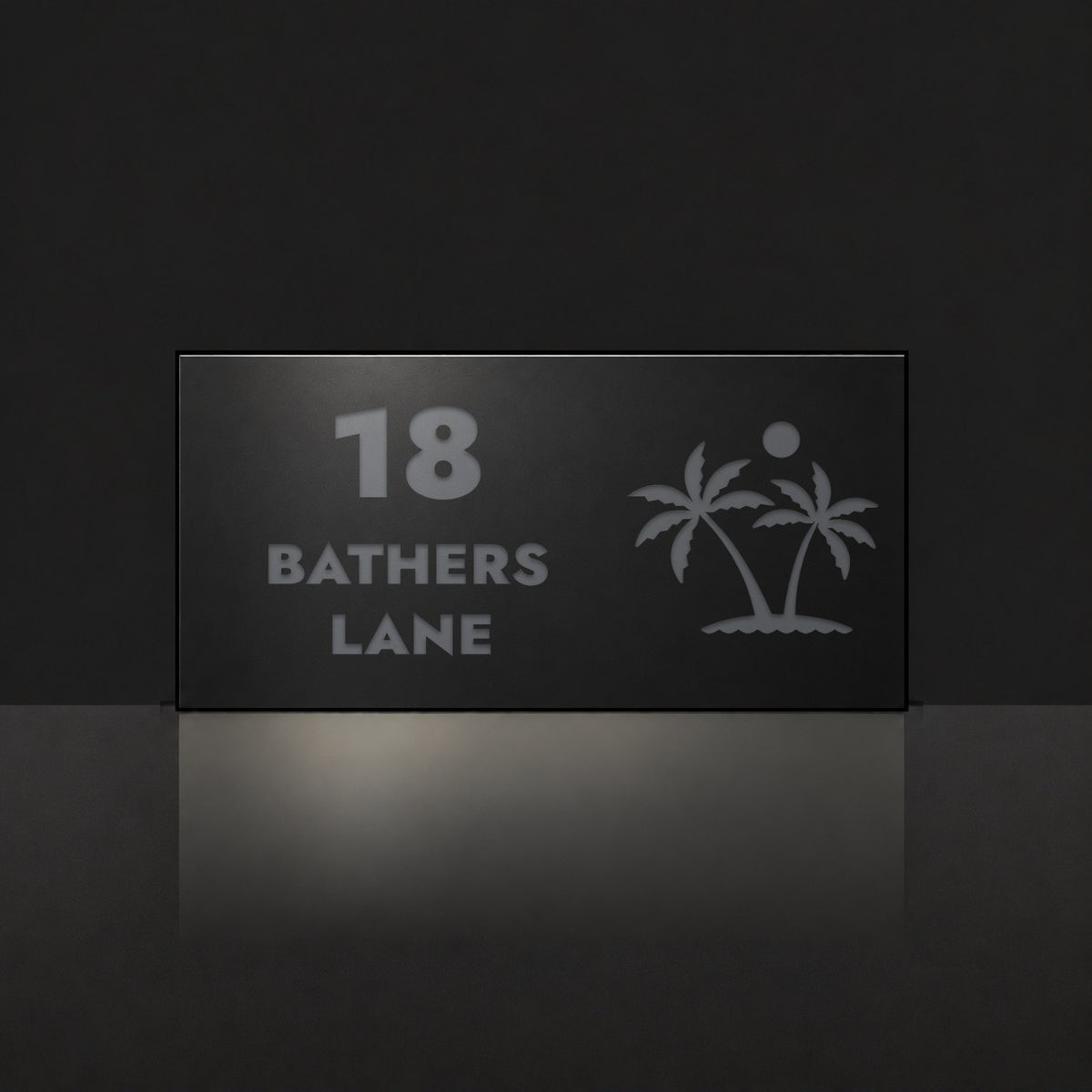Matte black house number and street name sign, The Yaroomba, reading 18 Bathers Lane in charcoal lettering, with palm trees and a sun.