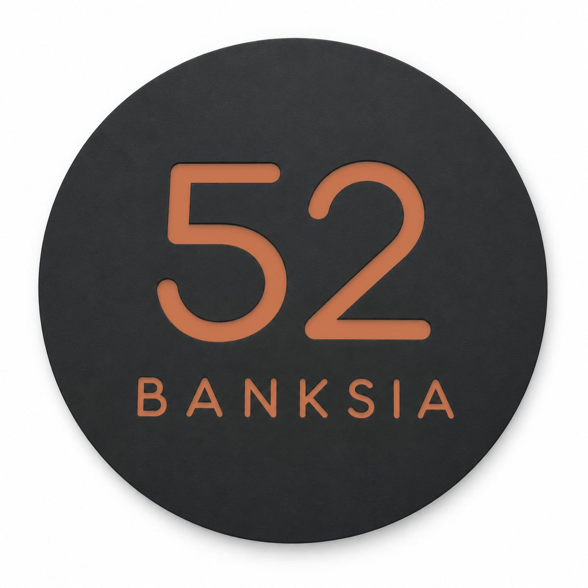 Black round house number and street name sign reading 52 Banksia in brushed copper, The Buderim style, on a plain white background.