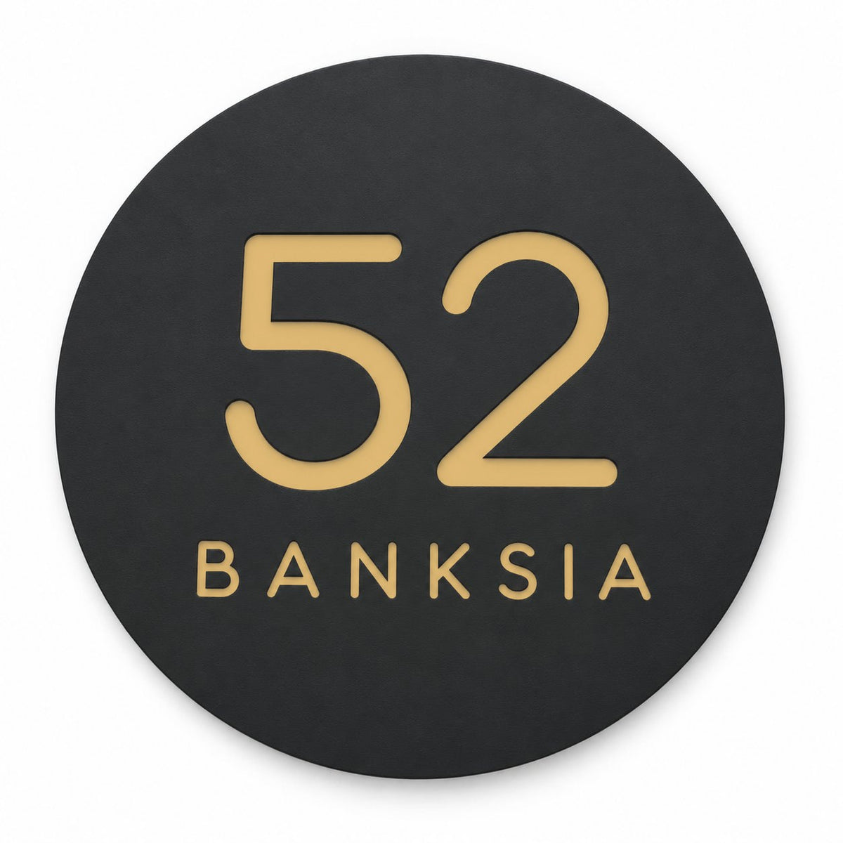 Black round house number and street name sign reading 52 Banksia in brushed gold, The Buderim style, on a plain white background.