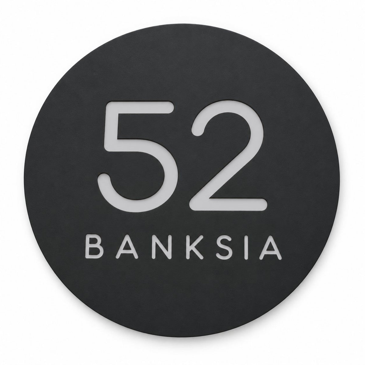 Black round house number and street name sign reading 52 Banksia in brushed silver, The Buderim style, on a plain white background.