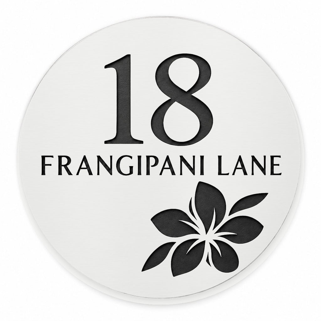 Matte white round house number and street name sign reading 18 Frangipani Lane with a frangipani flower cut through to black, The Currimundi style, on a plain white background.
